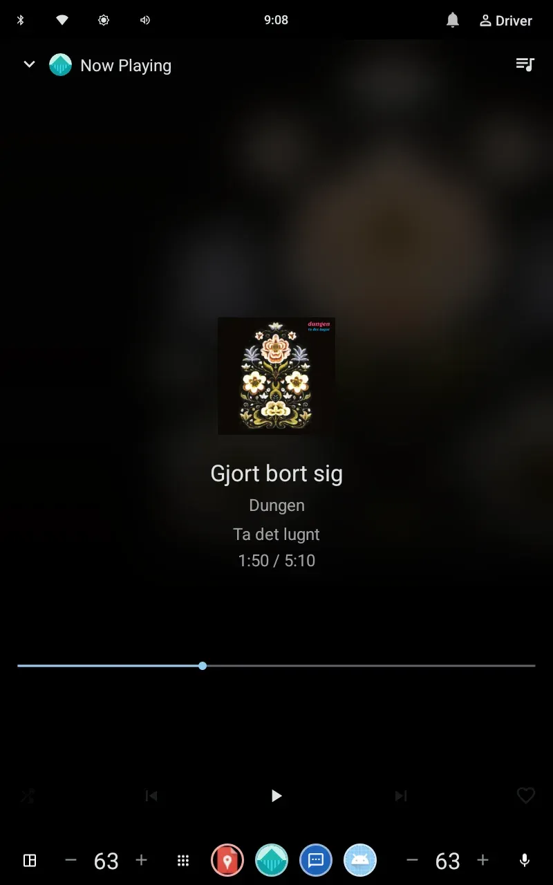 Now Playing screen in the car UI: cover art, track title, artist, elapsed and total time, seek bar, and shuffle, skip, play and heart controls